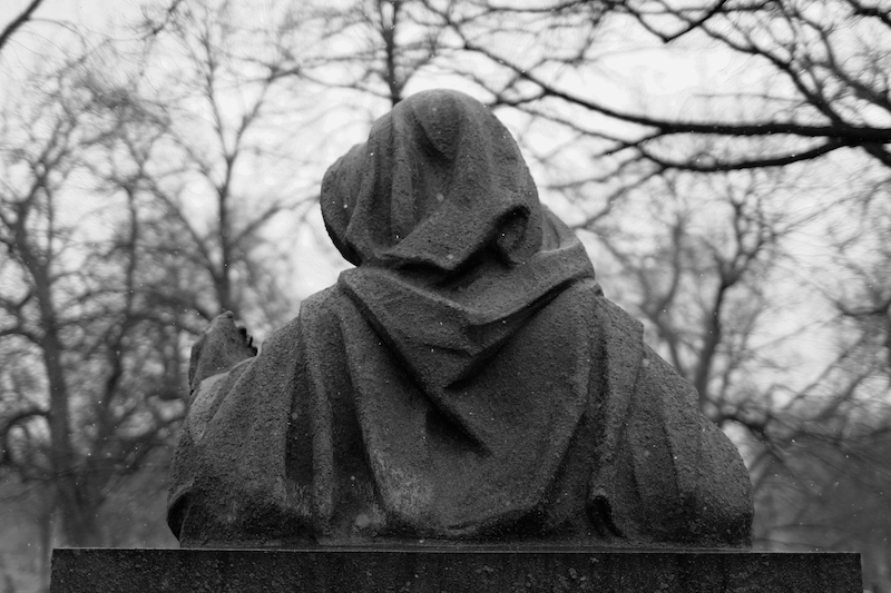 Mysterious stone statue from over the shoulder, looking at their hand